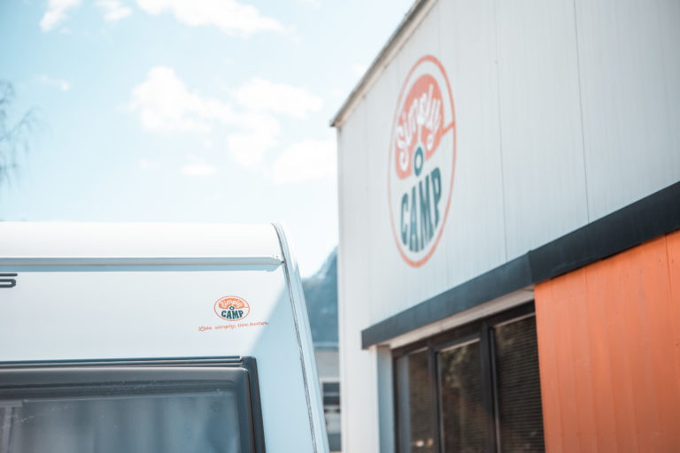 Wohnwagen vor der SimplyCamp Halle mit Firmenlogo