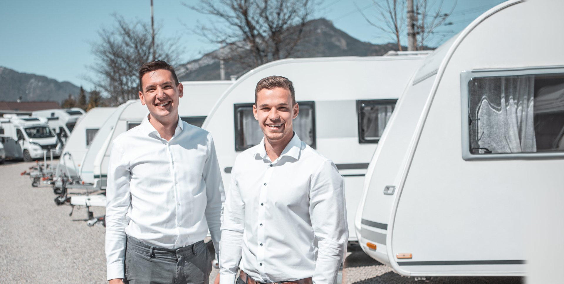 Das SimplyCamp-Team vor Wohnwagen am Firmengelände in Bad Goisern